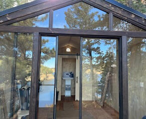 Forged metal door frames opening to the quiet space- surrounded by water and wood